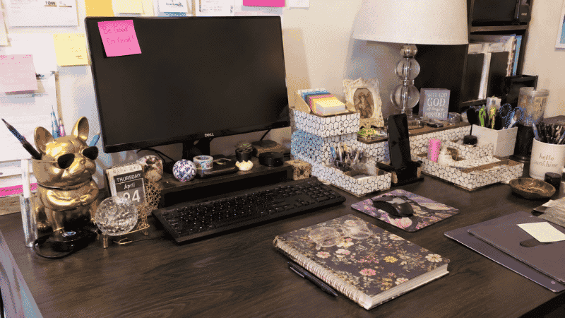 A cluttered desk surface overwhelmed with too many desk accessories including novelty items, matching sets, and unused organizers showing what not to buy