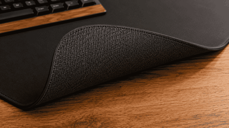 The underside of a desk mat showing a thick rubber non-slip backing that keeps the mat in place on the desk surface