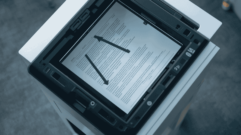 A close-up of a vertical document scanner demonstrating its space-saving U-turn paper path, ideal for small desks and compact workspaces.
